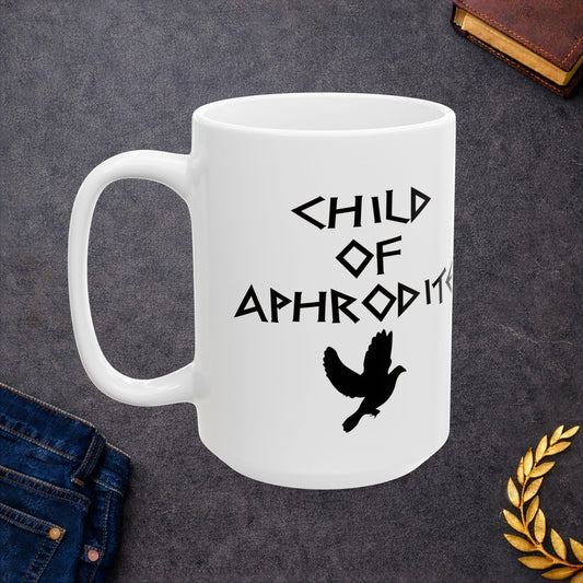 White ceramic mug featuring a minimalist, Greek-inspired graphic in black ink on a white background. The design reads 'CHILD OF APHRODITE' in a stylized, angular font, positioned above a clean, line-art graphic of a dove in flight.