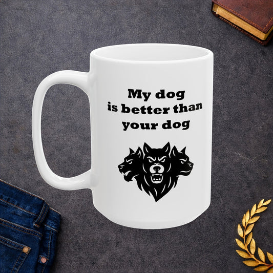 White ceramic mug with a minimalist black-and-white graphic featuring a bold, three-headed Cerberus illustration. The hound of the underworld is shown with snarling expressions and sharp teeth. Above the heads, the phrase "My dog is better than your dog" is written in a heavy, black slab-serif font. The design is a clean, modern take on Greek mythology with a humorous twist.