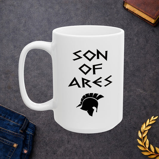 White ceramic mug featuring a minimalist, Greek-inspired graphic in black ink on a white background. The design reads 'SON OF ARES' in a stylized, angular font, positioned above a clean, line-art graphic of a Spartan-style plumed warrior helmet.