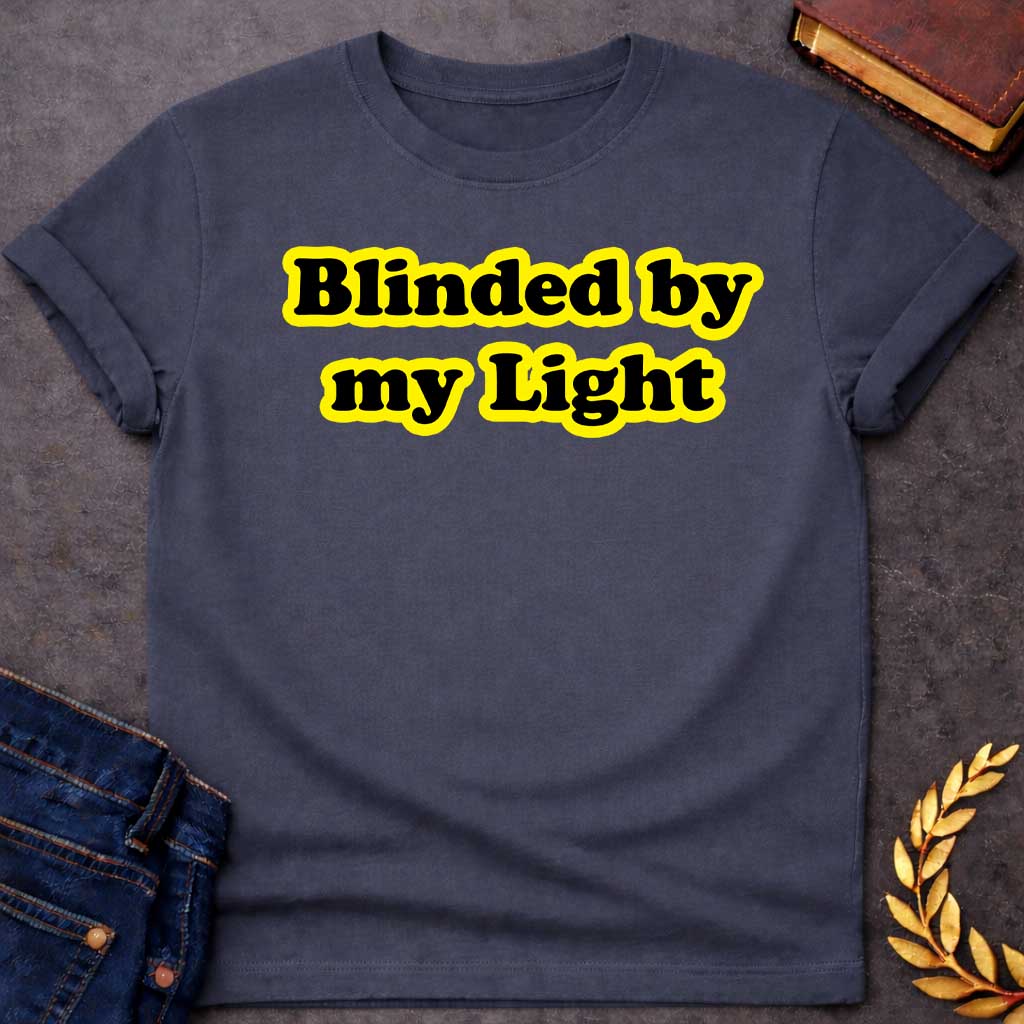 Dark Heather T-shirt Streetwear graphic design featuring the phrase "Blinded by my Light" in bold black bubble typography with a vibrant yellow glow. Retro-style aesthetic inspired by Greek mythology and Apollo, the god of light