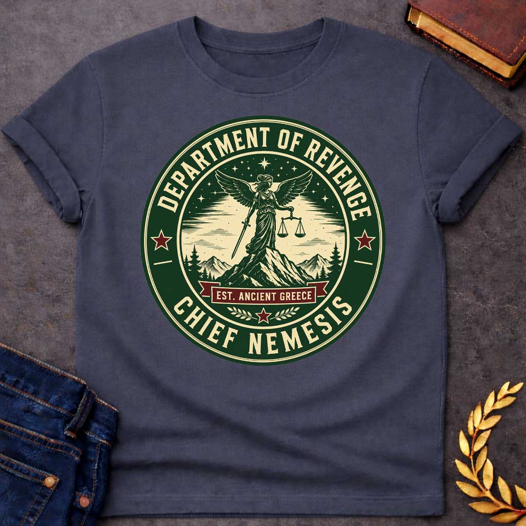 Dark Heather T-Shirt with an Official seal-style circular design in forest green, cream, and burgundy red. Features Nemesis, the winged Greek goddess, standing on a mountain peak holding scales of justice and a sword. Starry night sky, pine trees, and snow-capped mountains surround her. Text reads 'DEPARTMENT OF REVENGE' at top, 'CHIEF NEMESIS' at bottom, with 'EST. ANCIENT GREECE' on a burgundy banner. Red stars accent the design. Humorous parody of official government seals celebrating divine justice.