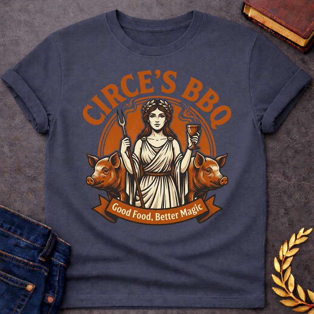 Dark Heather T-shirt with a Humorous BBQ restaurant emblem featuring Circe from Greek mythology in classical robes. She holds a trident fork and wine goblet. Two pigs flank her sides, representing her legendary power to transform men through magic and enchantment. Brown and cream aesthetic. Text reads 'Circe's BBQ' and 'Good Food, Better Magic.' Clever wordplay merges ancient witchcraft with modern barbecue culture and humorous transformation themes.