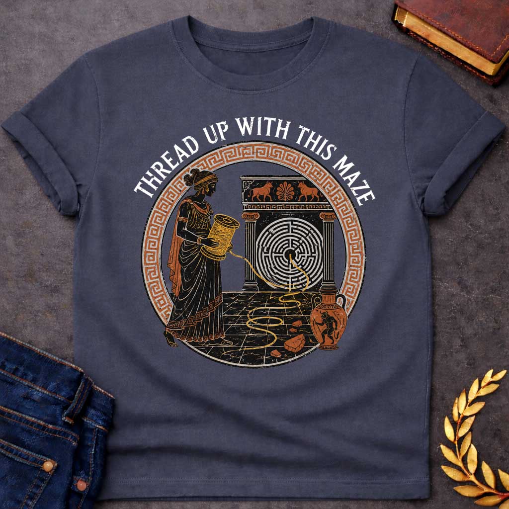 Dark Heather T-shirt with A distressed, ancient Greek pottery-style t-shirt graphic. Inside a circular terracotta Greek key frame, a black figure of Ariadne holds a large spool, unwinding a golden thread that leads into a circular maze on a stone structure. An amphora vase with a Minotaur stands nearby. Arched above the scene, white text reads "THREAD UP WITH THIS MAZE" in a rustic serif font.