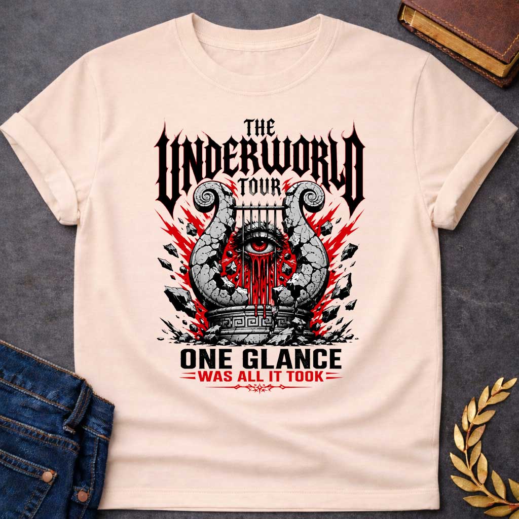 Natural t-shirt in heavy metal band-poster style: a cracked stone lyre with a bleeding red eye at its center sits atop a Greek pedestal, framed by jagged red lightning bolts and scattered rubble. Gothic spiked black lettering and bold red accent text complete the design