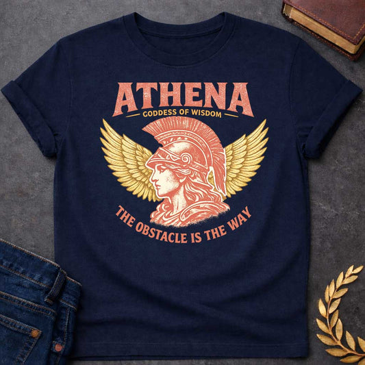 Navy t-shirt graphic featuring a side-profile illustration of Athena wearing a Corinthian helmet with a red plume, flanked by large golden wings. Text reads "ATHENA – Goddess of Wisdom" arched above and "The Obstacle Is the Way" curved below, in a vintage Greek mythology style with rose and gold tones