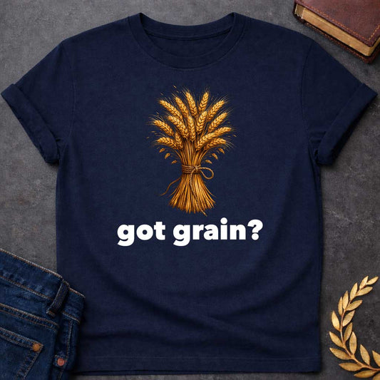 Navy T-shirt graphic featuring a detailed realistic illustration of a golden wheat sheaf tied together with a twisted rope bow, set against a white background, with bold black text below reading "got grain?" in a humorous nod to Demeter, Greek Goddess of the Harvest