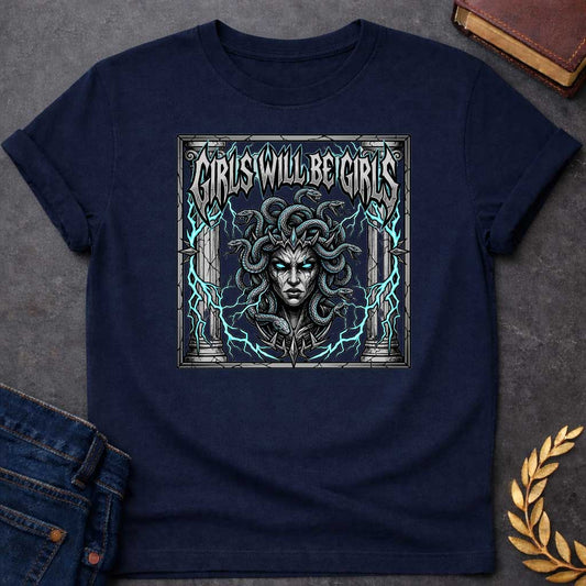 Navy T-shirt graphic in a dark heavy metal style featuring a fierce front-facing illustration of Medusa with glowing teal eyes, a spiked crown, and writhing snakes for hair, surrounded by electric teal lightning bolts and flanked by cracked stone Greek columns, all within a crumbling stone frame. Bold metallic gothic lettering across the top reads "Girls Will Be Girls,"