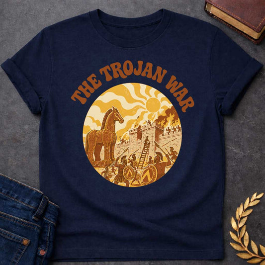 Navy T-shirt featuring bold groovy 1970s-style arched brown text reading "The Trojan War" above a circular vintage illustration depicting the siege of Troy — the Trojan Horse stands to the left while Greek warriors with Spartan shields and spears storm the burning walls of Troy using a ladder, under a stylized wavy sun, rendered in a warm retro palette of golden yellow, burnt orange, and brown tones