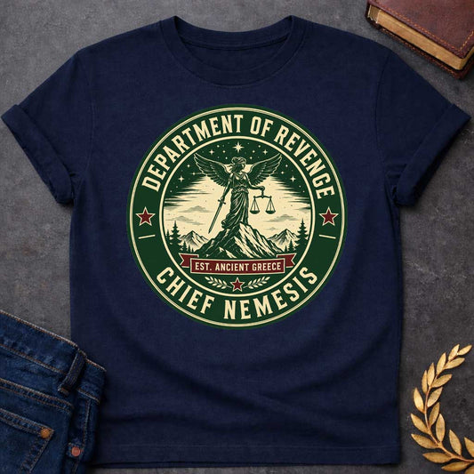 Navy T-Shirt with an Official seal-style circular design in forest green, cream, and burgundy red. Features Nemesis, the winged Greek goddess, standing on a mountain peak holding scales of justice and a sword. Starry night sky, pine trees, and snow-capped mountains surround her. Text reads 'DEPARTMENT OF REVENGE' at top, 'CHIEF NEMESIS' at bottom, with 'EST. ANCIENT GREECE' on a burgundy banner. Red stars accent the design. Humorous parody of official government seals celebrating divine justice.