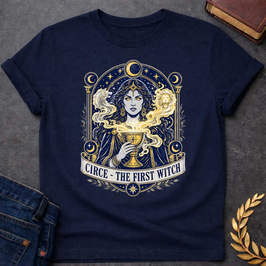 Navy T-shirt with a Mystical tarot-style portrait of Circe, the first witch from Greek mythology, rendered in navy blue and gold. She displays golden glowing eyes and magical hair infused with light energy. Twin lion heads flank her head symbolizing divine power. She holds an ornate golden goblet overflowing with luminous magic. Moon phases in crescent form circle her ethereal figure. Ornate architectural frame with columns and celestial decorations. Gold stars scatter throughout. Banner reads 'Circe - The