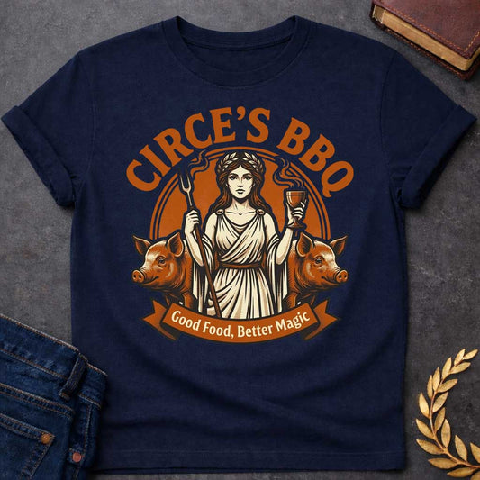 Navy T-shirt with a Humorous BBQ restaurant emblem featuring Circe from Greek mythology in classical robes. She holds a trident fork and wine goblet. Two pigs flank her sides, representing her legendary power to transform men through magic and enchantment. Brown and cream aesthetic. Text reads 'Circe's BBQ' and 'Good Food, Better Magic.' Clever wordplay merges ancient witchcraft with modern barbecue culture and humorous transformation themes.