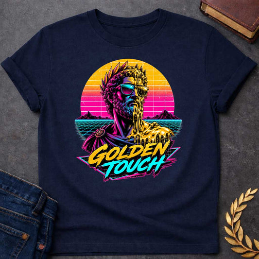 Navy t-shirt with A Retro synthwave-inspired Greek mythology design featuring a stylized bust of King Midas wearing sunglasses as molten gold drips over half his face and shoulder. A vibrant neon sunset, grid landscape, and mountains create an 80s vaporwave backdrop. Bold brush lettering reads "Golden Touch" in gold and teal, using bright pink, purple, cyan, and gold for a striking vintage aesthetic.