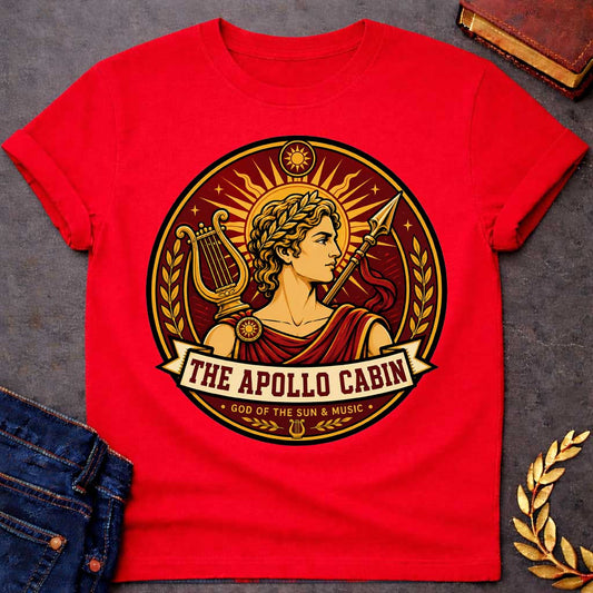 Red t-shirt with a Apollo Greek mythology cabin design featuring the god of the sun and music wearing a golden laurel crown, framed by a radiant sun, lyre, spear, stars, and laurel branches. Rich red, gold, and cream circular camp-style emblem includes the text “The Apollo Cabin” and “God of the Sun & Music.