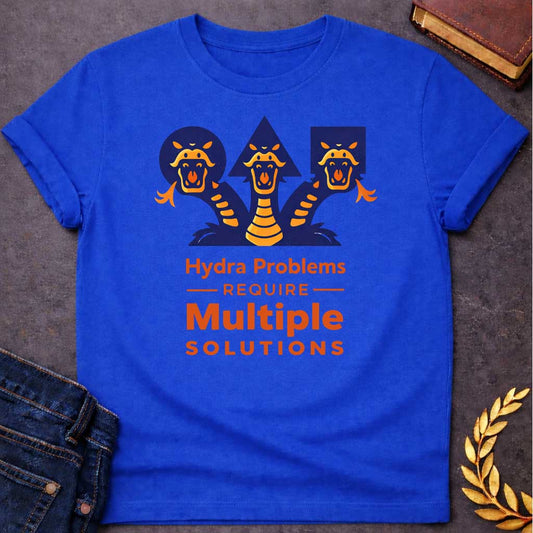 Royal T-shirt with a graphic featuring a bold modern illustrated design of the Hydra, the multi-headed serpent of Greek mythology, depicted as three snarling orange and navy snake heads rising against geometric navy shapes a circle, triangle, and rectangle. Bold orange text below reads "Hydra Problems Require Multiple Solutions" with "Require" flanked by horizontal rules in a smaller weight