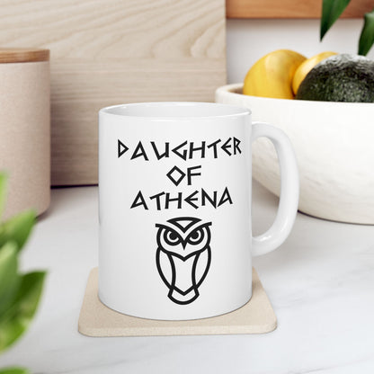 White ceramic mug graphic featuring bold ancient Greek-style lettering reading "Daughter of Athena" above a clean geometric line-art owl icon — referencing Athena, the Greek Goddess of Wisdom, whose sacred symbol is the owl, rendered in white on black in a striking high-contrast design.