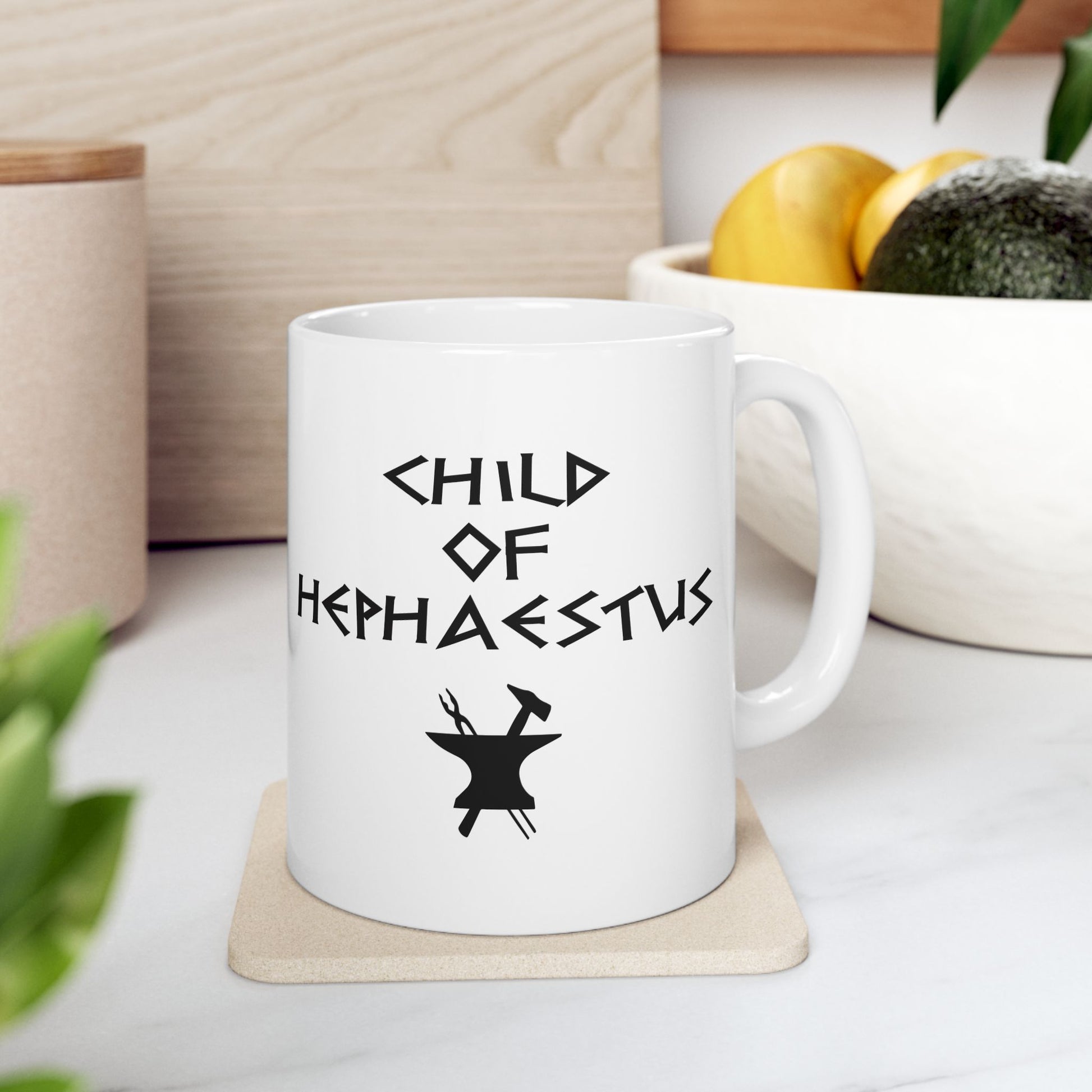 A minimalist black graphic for a white ceramic mug. The design features a central silhouette of a blacksmith's anvil with a hammer and tongs crossed behind it. Above the tools, the text "CHILD OF HEPHAESTUS" is written in a sharp, angular font inspired by ancient Greek inscriptions. The entire illustration is rendered in a clean, solid black style.