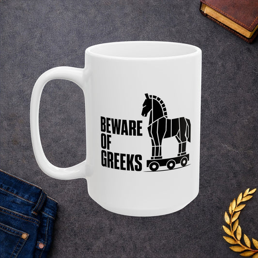 White ceramic mug with a minimalist black-and-white graphic featuring a stylized, geometric silhouette of the Trojan Horse on a wheeled platform. To the left of the horse, the text "BEWARE OF GREEKS" is written vertically in a bold, stacked, black sans-serif font. The design uses clean lines and high contrast on a plain background, offering a modern, minimalist take on the classic Greek mythological tale.