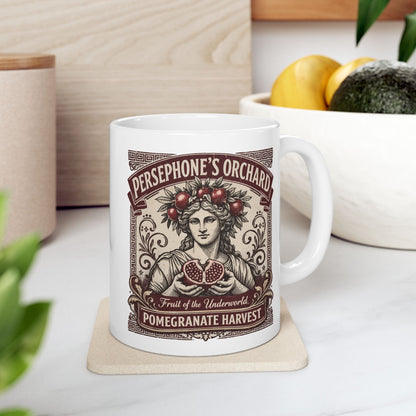 White ceramic mug with a vintage botanical-style illustration of the goddess Persephone, crowned with pomegranates and holding a halved pomegranate revealing its seeds. The artwork is framed by Greek key borders and floral scrolls in a deep burgundy hue. Banners above and below read "PERSEPHONE'S ORCHARD," "Fruit of the Underworld," and "POMEGRANATE HARVEST." The design has an elegant, aged-label aesthetic