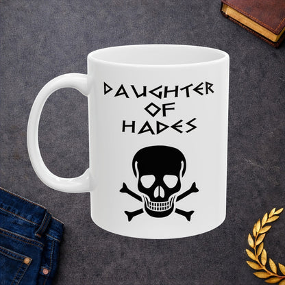 A bold, dark-themed graphic for a white ceramic mug. The design features a large, detailed outline of a skull and crossbones at the center. Above the skull, the words "DAUGHTER OF HADES" are written in a sharp, ancient Greek-inspired angular font. The entire design is rendered in a clean, high-contrast black outline style.
