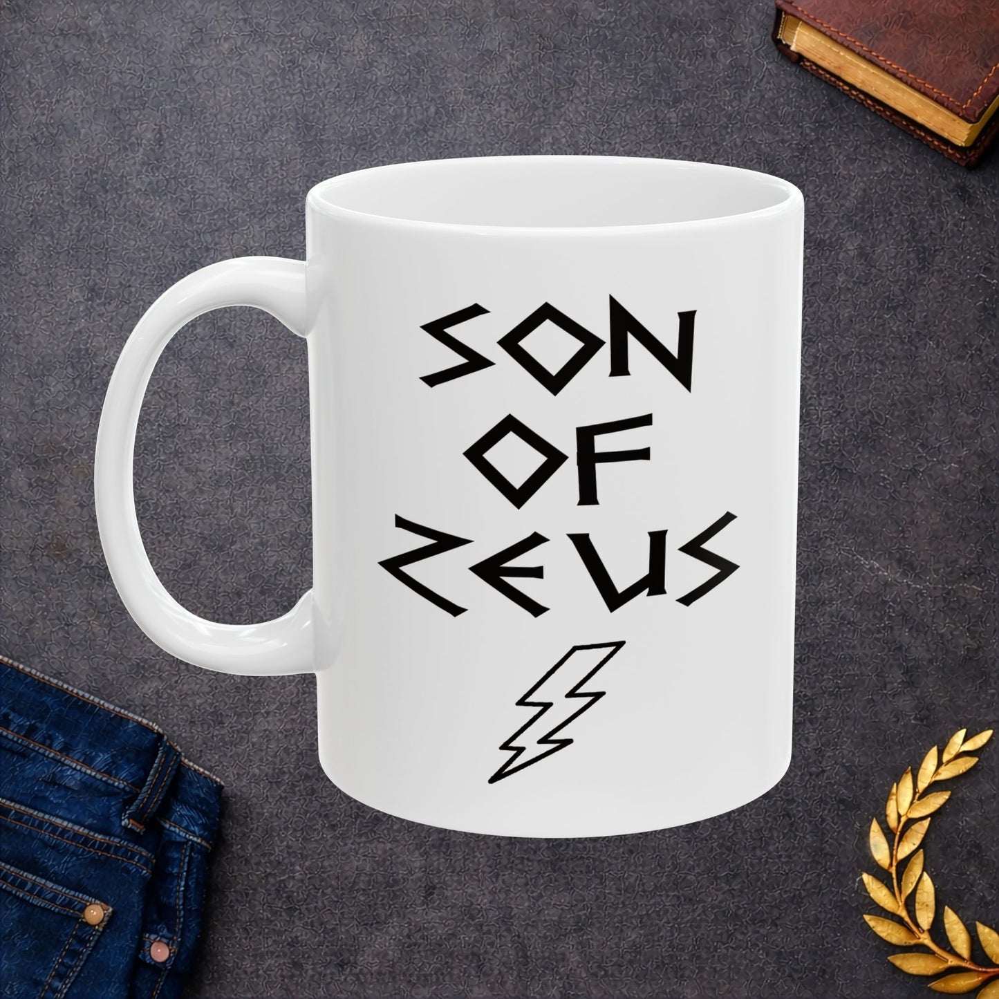 A minimalist black graphic for a white ceramic mug featuring a large, central outline of a lightning bolt. Above the bolt, the text "SON OF ZEUS" is written in a sharp, angular font inspired by ancient Greek inscriptions. The entire design is rendered in a clean, high-contrast black outline style.