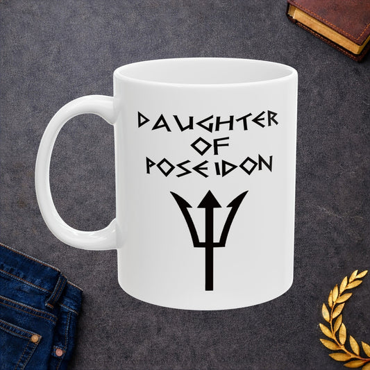 A minimalist black graphic for a white ceramic mug featuring a central silhouette of a trident. Above the trident, the text "DAUGHTER OF POSEIDON" is written in a sharp, angular font reminiscent of ancient Greek epigraphy. The entire design is rendered in a clean, high-contrast black style.