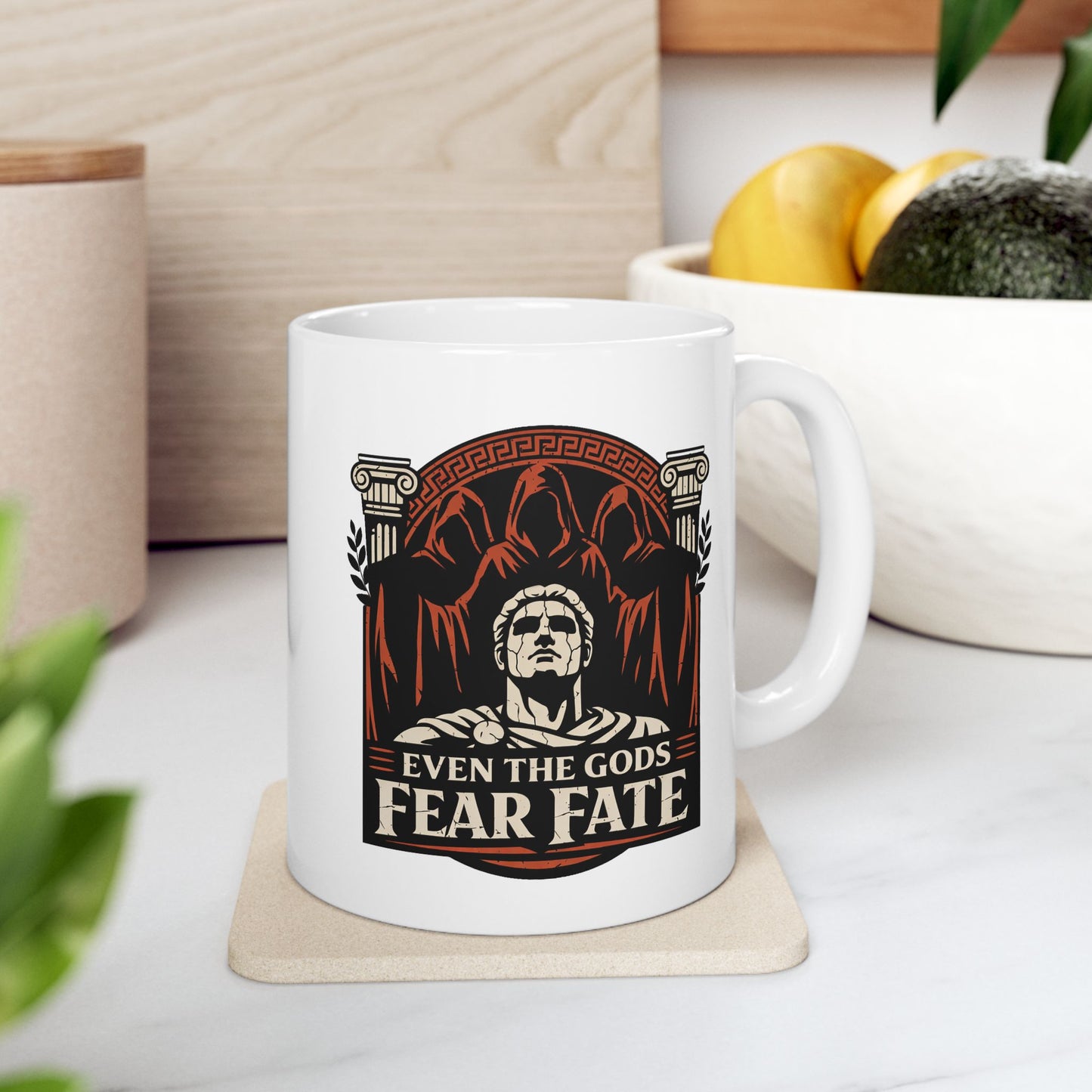 White ceramic mug with a bold, three-tone graphic in black, white, and terracotta. The design features a cracked marble bust of a Greek god positioned in front of three looming, hooded figures representing the Fates. This central imagery is framed by Ionic columns and a Greek key arch. Below, the text reads "EVEN THE GODS FEAR FATE" in a strong, weathered serif font. The aesthetic is inspired by ancient Greek pottery.