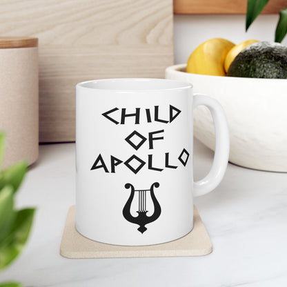 White ceramic mug featuring a minimalist, Greek-inspired graphic in black ink on a white background. The design reads 'CHILD OF APOLLO' in a stylized, angular font, positioned above a clean, line-art graphic of a classical lyre.