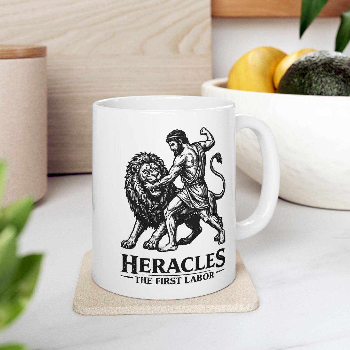 White ceramic mug with a striking black-and-white linocut illustration depicting the Greek hero Heracles wrestling the Nemean Lion. The muscular hero forces his arm into the lion’s open jaws while raising his fist to strike. Below the dynamic scene, bold text reads "HERACLES" followed by a sub-caption that reads "THE FIRST LABOR." The design has a classic, high-contrast vintage woodcut engraving style.