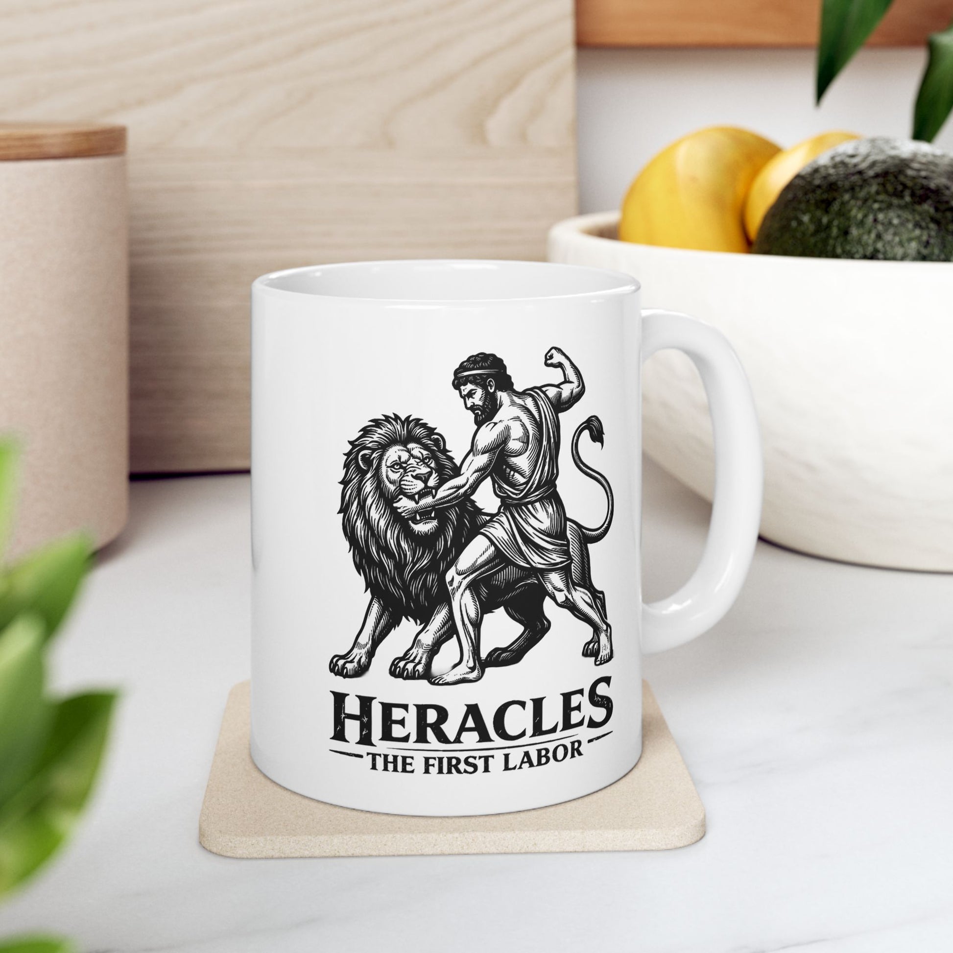 White ceramic mug with a striking black-and-white linocut illustration depicting the Greek hero Heracles wrestling the Nemean Lion. The muscular hero forces his arm into the lion’s open jaws while raising his fist to strike. Below the dynamic scene, bold text reads "HERACLES" followed by a sub-caption that reads "THE FIRST LABOR." The design has a classic, high-contrast vintage woodcut engraving style.