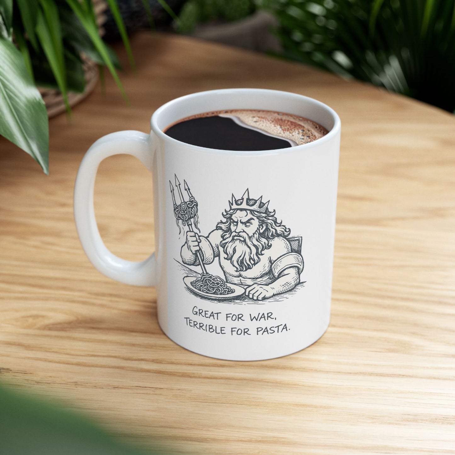 White ceramic mug with a humorous black-and-white sketch of a frustrated Greek god Poseidon attempting to eat spaghetti with his large trident. Strands of pasta are tangled awkwardly around the tines of the weapon. Below the illustration, the caption reads "GREAT FOR WAR, TERRIBLE FOR PASTA" in a distressed, handwritten-style font. The design features a clean, comic-style aesthetic.