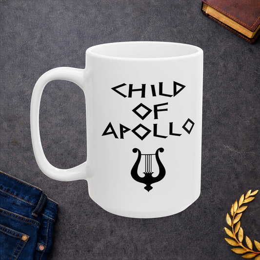 White ceramic mug featuring a minimalist, Greek-inspired graphic in black ink on a white background. The design reads 'CHILD OF APOLLO' in a stylized, angular font, positioned above a clean, line-art graphic of a classical lyre.