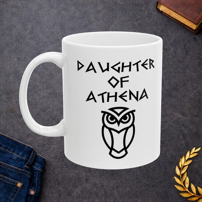 White ceramic mug graphic featuring bold ancient Greek-style lettering reading "Daughter of Athena" above a clean geometric line-art owl icon — referencing Athena, the Greek Goddess of Wisdom, whose sacred symbol is the owl, rendered in white on black in a striking high-contrast design.