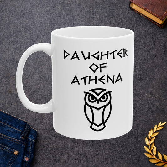 White ceramic mug graphic featuring bold ancient Greek-style lettering reading "Daughter of Athena" above a clean geometric line-art owl icon — referencing Athena, the Greek Goddess of Wisdom, whose sacred symbol is the owl, rendered in white on black in a striking high-contrast design.