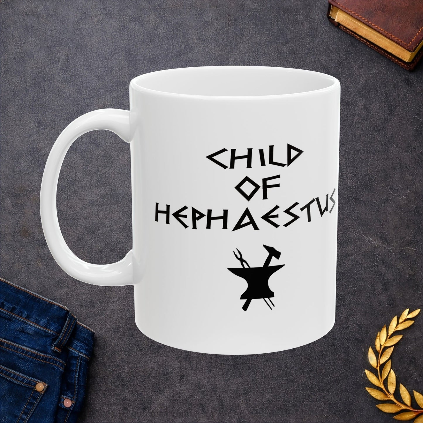 A minimalist black graphic for a white ceramic mug. The design features a central silhouette of a blacksmith's anvil with a hammer and tongs crossed behind it. Above the tools, the text "CHILD OF HEPHAESTUS" is written in a sharp, angular font inspired by ancient Greek inscriptions. The entire illustration is rendered in a clean, solid black style.