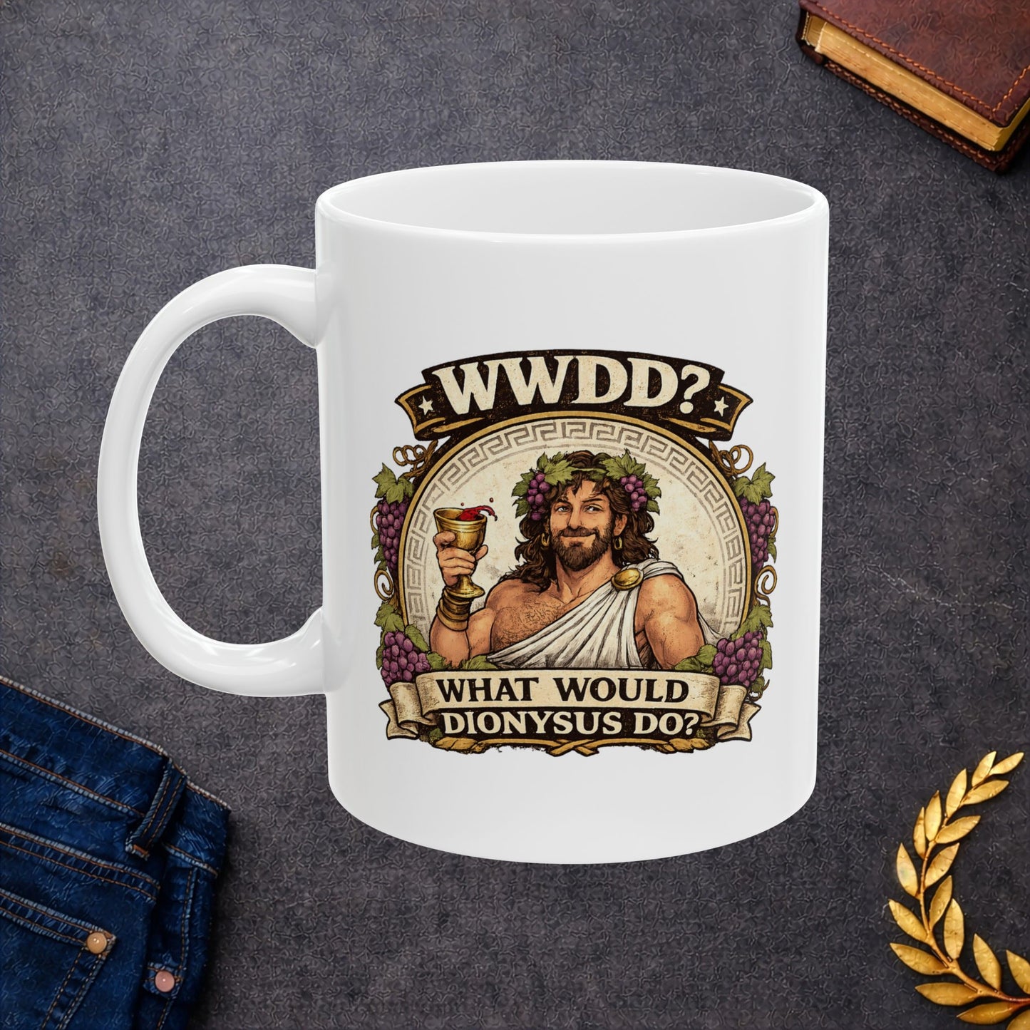 White ceramic mug with a vintage-style illustration of Dionysus, the Greek god of wine, smiling as he raises a golden goblet splashing with red wine. He wears a toga, a laurel wreath interwoven with purple grapes, and is framed by a circular Greek key pattern and clusters of grapes. Banners above and below read "WWDD?" and "WHAT WOULD DIONYSUS DO?" The design features a detailed, textured classical aesthetic.