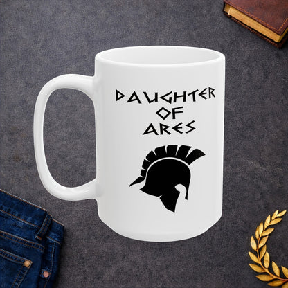 White ceramic mug featuring a minimalist, Greek-inspired graphic in black ink on a white background. The design reads 'DAUGHTER OF ARES' in a stylized, angular font, positioned above a clean, line-art graphic of a Spartan-style plumed warrior helmet.