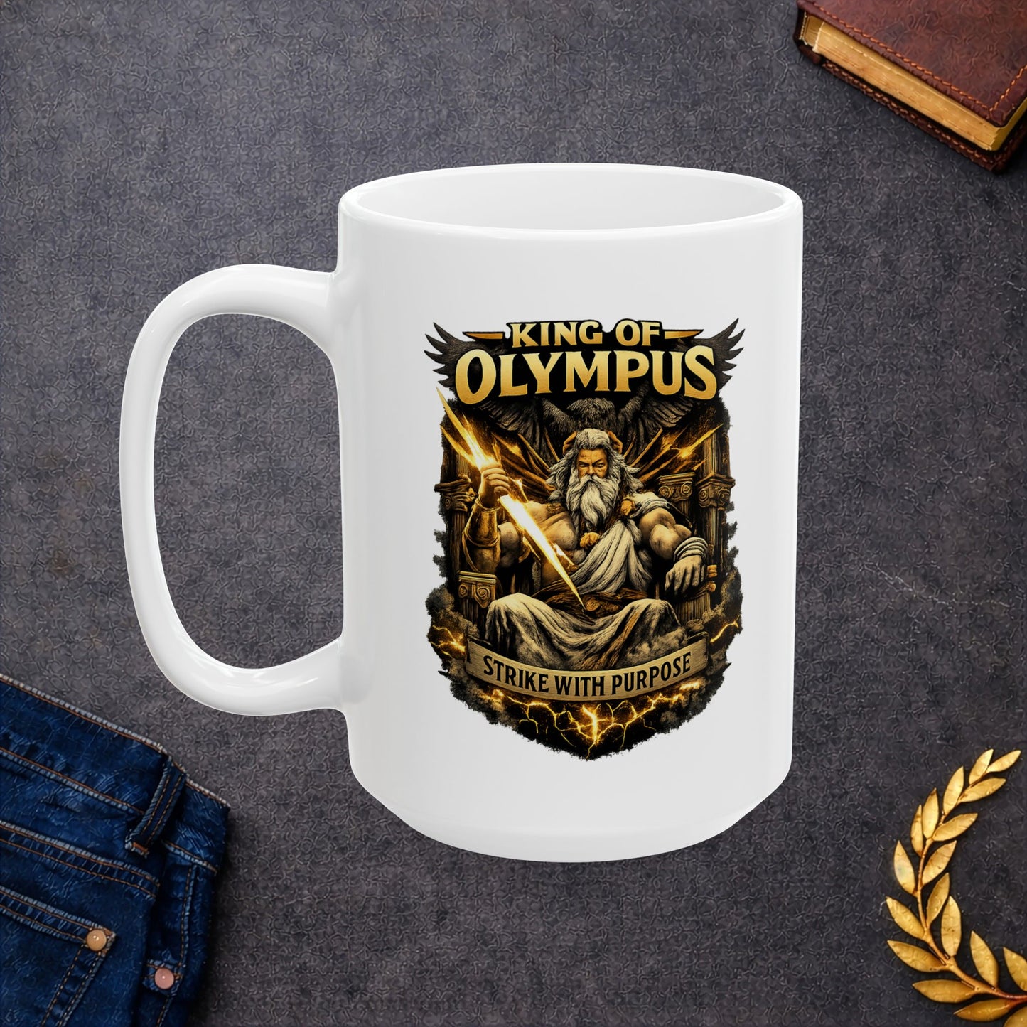 White ceramic mug with a powerful, high-contrast illustration of Zeus seated on a golden throne, holding a brilliantly glowing lightning bolt. He is depicted with a long white beard, stern expression, and muscular build, with a large dark eagle behind him. The bold golden text "KING OF OLYMPUS" arches at the top, and a weathered scroll at the bottom displays the inspiring slogan "STRIKE WITH PURPOSE."