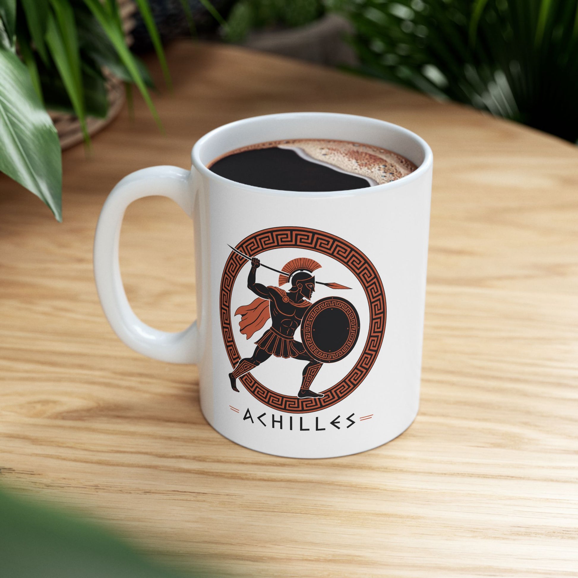 White ceramic mug with a Ancient Greek pottery-style illustration of Achilles, the legendary Trojan War hero, in terracotta orange and black. The warrior wears a crested Corinthian helmet, pleated skirt, and flowing cape while raising a spear in dynamic battle pose. He holds a round shield with Greek key pattern. Enclosed in a circular meander pattern border. The name 'ACHILLES' appears below in geometric letters. Celebrates the hero's legendary martial strength.