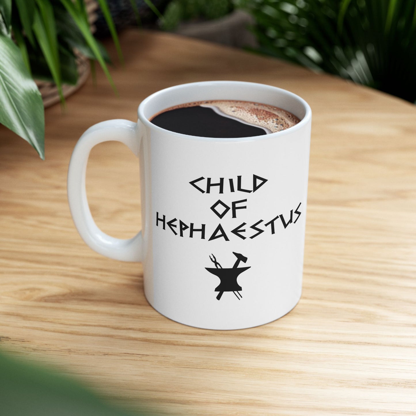 A minimalist black graphic for a white ceramic mug. The design features a central silhouette of a blacksmith's anvil with a hammer and tongs crossed behind it. Above the tools, the text "CHILD OF HEPHAESTUS" is written in a sharp, angular font inspired by ancient Greek inscriptions. The entire illustration is rendered in a clean, solid black style.