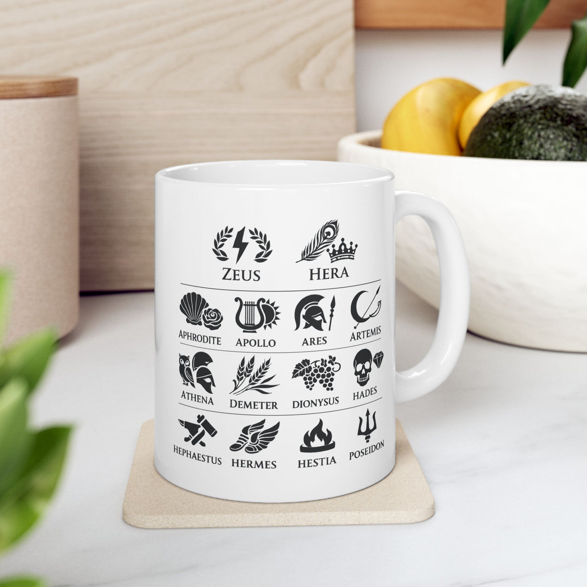 White ceramic mug with a Greek mythology gods icon chart featuring symbolic illustrations for Zeus, Hera, Aphrodite, Apollo, Ares, Artemis, Athena, Demeter, Dionysus, Hades, Hephaestus, Hermes, Hestia, and Poseidon. Black icons include lightning, peacock feather, rose, lyre, helmet, bow, owl, wheat, grapes, skull, anvil, winged sandals, flame, and trident.