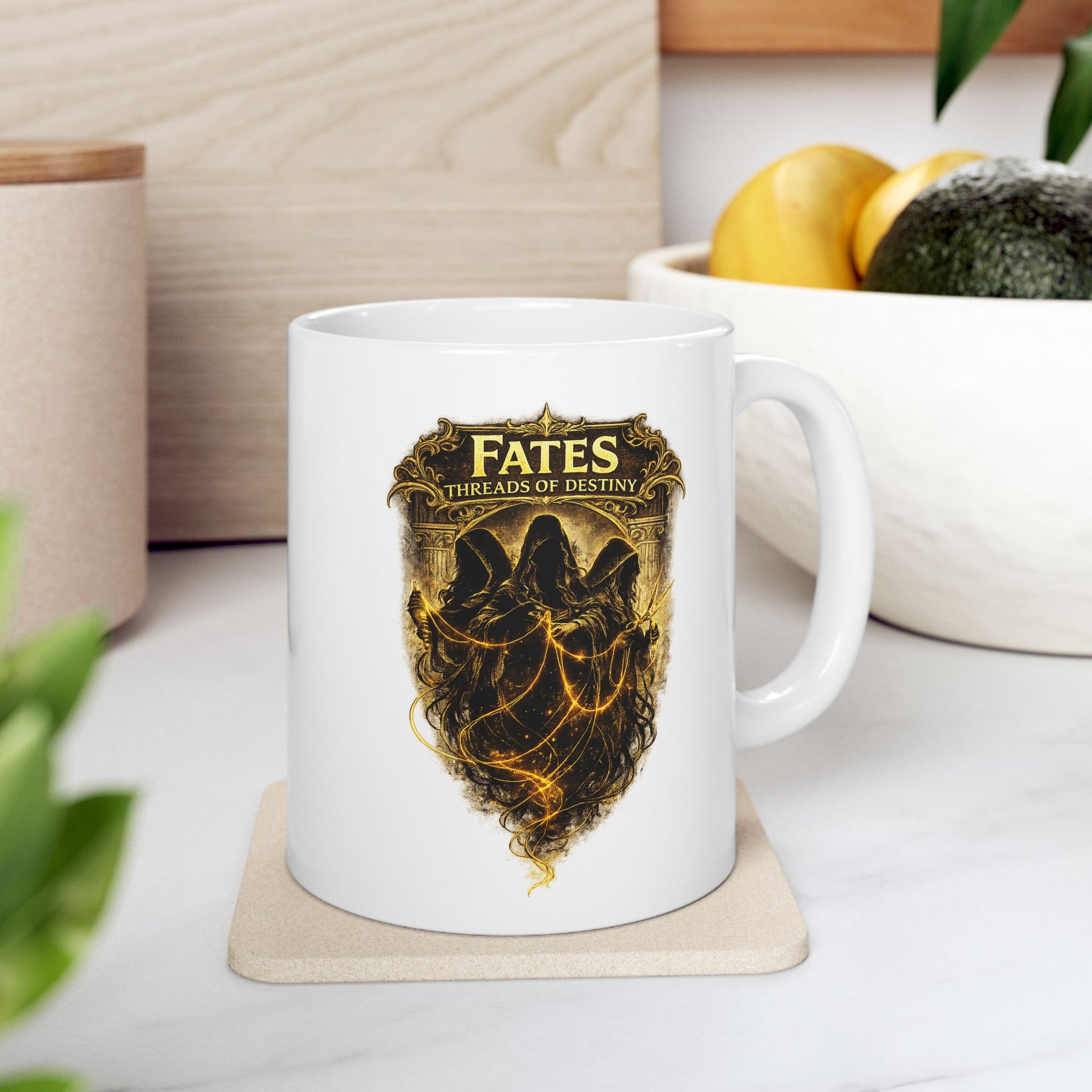 White ceramic mug with a dramatic, gold-toned illustration featuring the three Fates as hooded, shadowy figures. They are shown spinning, measuring, and cutting glowing golden threads of light against a dark background. Above them, a decorative golden frame contains the words "FATES" and "THREADS OF DESTINY." The artwork has a mystical, high-contrast aesthetic with intricate classical details and ethereal lighting.