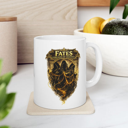 White ceramic mug with a dramatic, gold-toned illustration featuring the three Fates as hooded, shadowy figures. They are shown spinning, measuring, and cutting glowing golden threads of light against a dark background. Above them, a decorative golden frame contains the words "FATES" and "THREADS OF DESTINY." The artwork has a mystical, high-contrast aesthetic with intricate classical details and ethereal lighting.