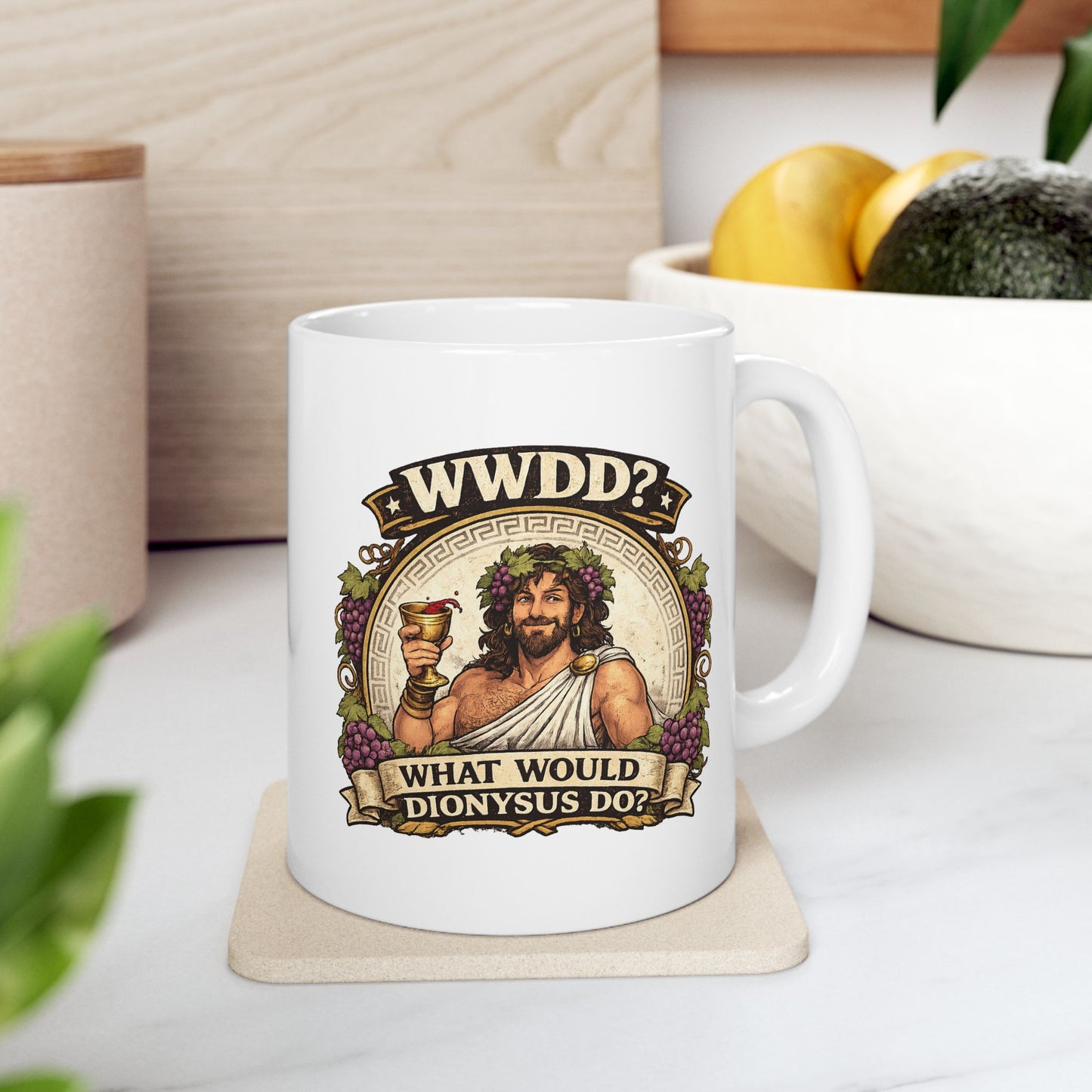 White ceramic mug with a vintage-style illustration of Dionysus, the Greek god of wine, smiling as he raises a golden goblet splashing with red wine. He wears a toga, a laurel wreath interwoven with purple grapes, and is framed by a circular Greek key pattern and clusters of grapes. Banners above and below read "WWDD?" and "WHAT WOULD DIONYSUS DO?" The design features a detailed, textured classical aesthetic.