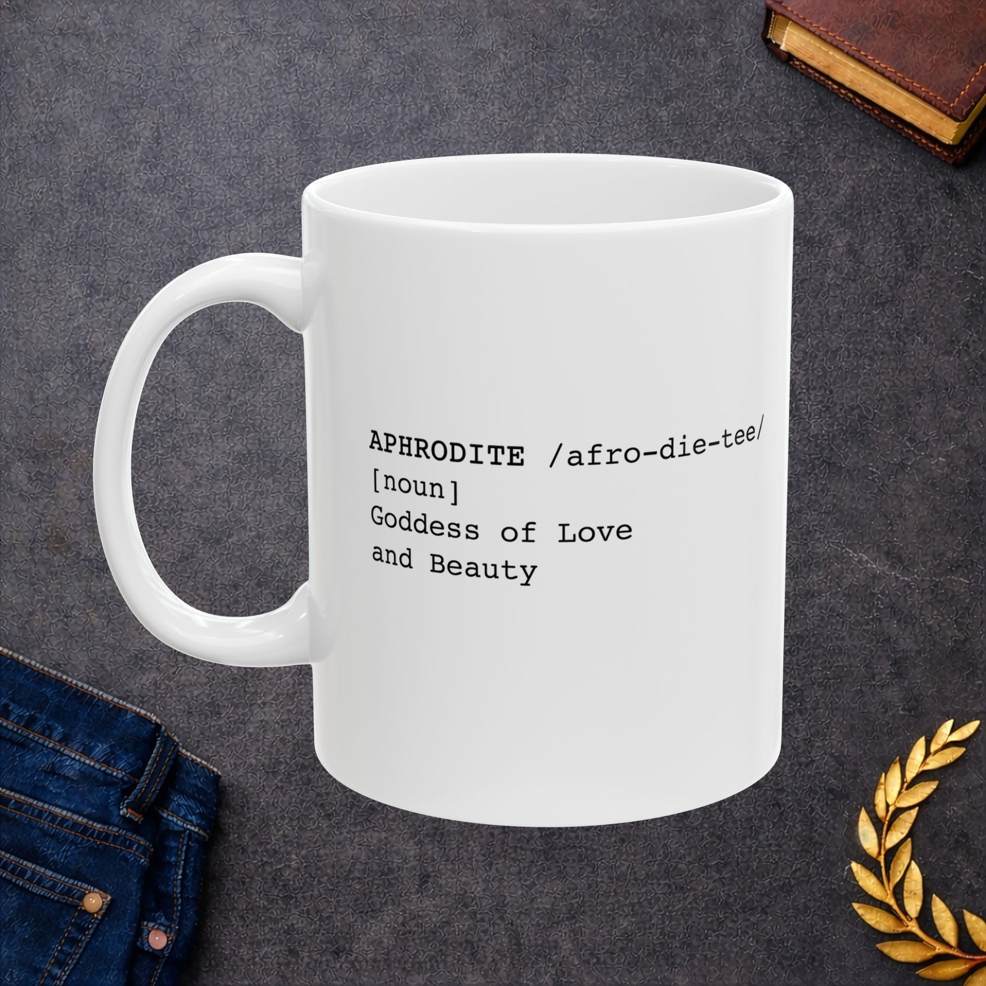 White ceramic mug featuring a dictionary-style definition graphic in black text on a white background. The text reads: 'APHRODITE /afro-die-tee/ [noun] Goddess of Love and Beauty.