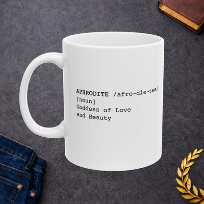White ceramic mug featuring a dictionary-style definition graphic in black text on a white background. The text reads: 'APHRODITE /afro-die-tee/ [noun] Goddess of Love and Beauty.