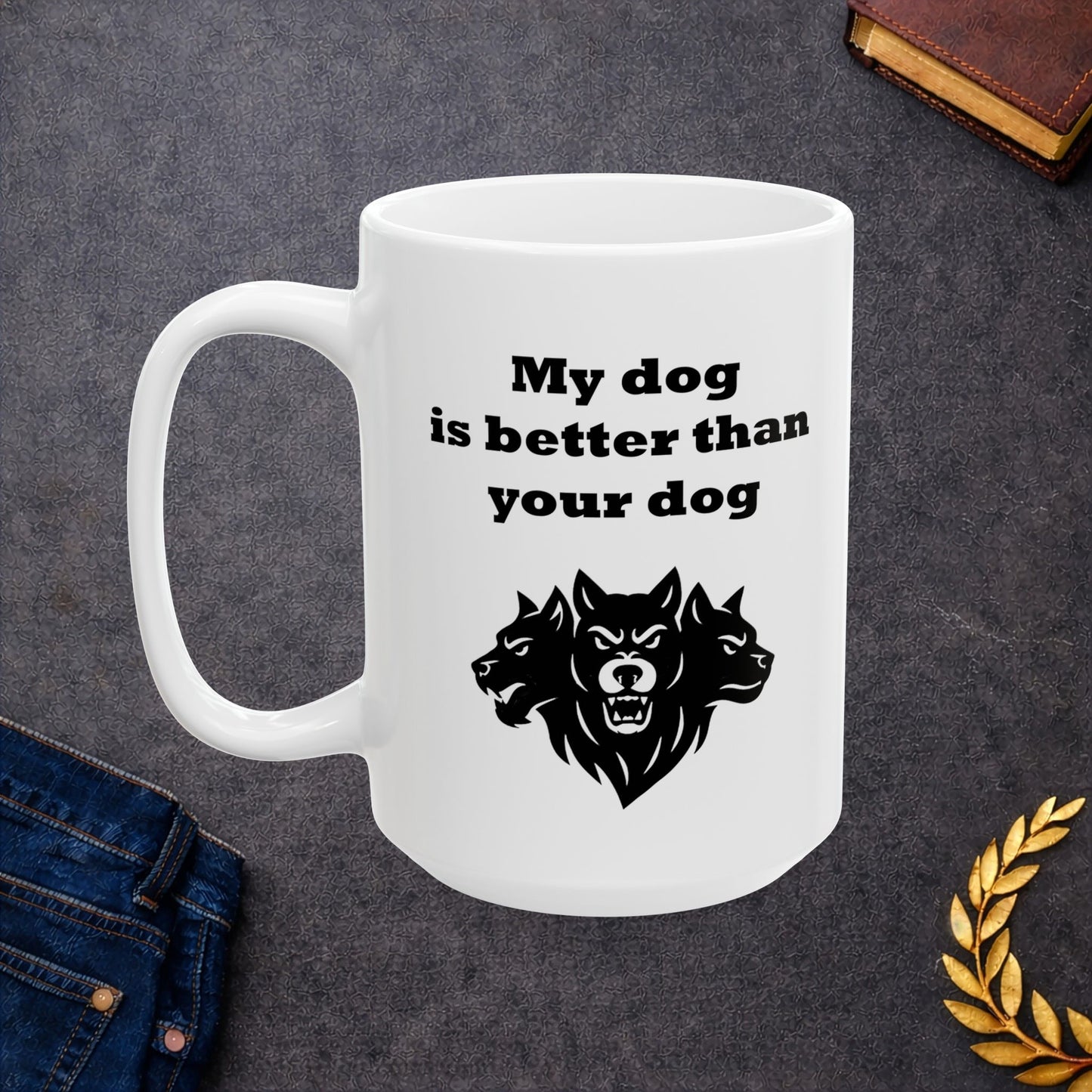 White ceramic mug with a minimalist black-and-white graphic featuring a bold, three-headed Cerberus illustration. The hound of the underworld is shown with snarling expressions and sharp teeth. Above the heads, the phrase "My dog is better than your dog" is written in a heavy, black slab-serif font. The design is a clean, modern take on Greek mythology with a humorous twist.