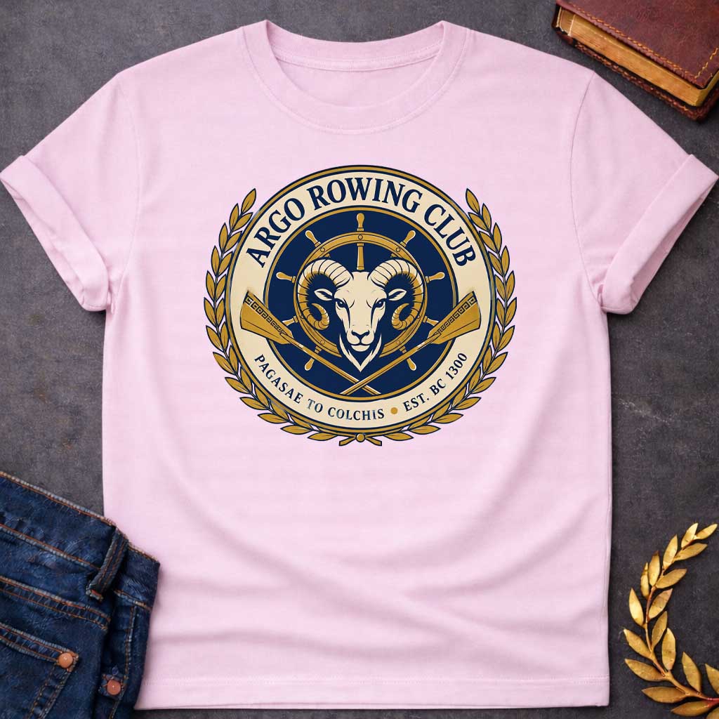 Light Pink T-shirt with A Nautical emblem of Argo Rowing Club in navy and gold featuring a golden ram's head at center, representing the mythological golden fleece. A ship's wheel rises above, flanked by crossed oars with Greek key patterns. Laurel wreaths frame the circular design. Text reads 'Argo Rowing Club' and 'Pacasae to Colchis Est. BRC 1300.' Celebrates the legendary quest of Jason and the Argonauts with modern rowing club aesthetics and classical maritime imagery.