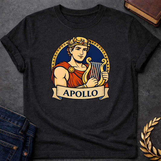 Black T-shirt graphic featuring a vibrant illustrated portrait of Apollo, the Greek God of the Sun and Music, with short curly hair and a gold laurel crown, wearing a red draped robe fastened with a gold brooch, playing a golden lyre. He is framed within a gold circular border against a navy background, with a scroll banner below reading "Apollo," in a bold tattoo-inspired style with navy, gold, and red tones