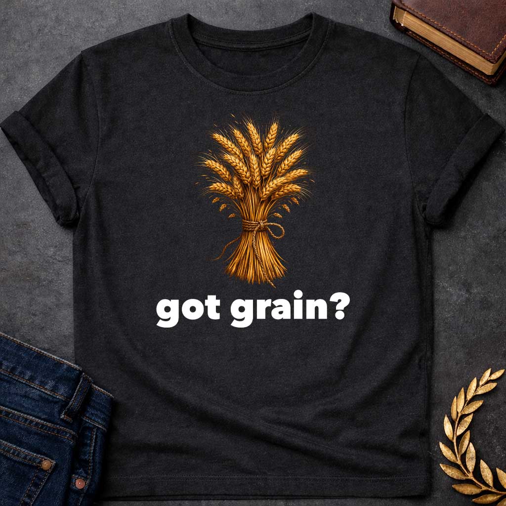 Black T-shirt graphic featuring a detailed realistic illustration of a golden wheat sheaf tied together with a twisted rope bow, set against a white background, with bold black text below reading "got grain?" in a humorous nod to Demeter, Greek Goddess of the Harvest