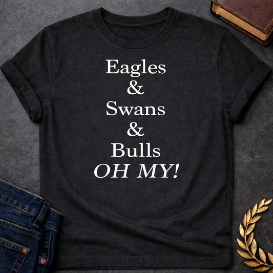 Black T-shirt graphic in white featuring large bold serif text reading "Eagles & Swans & Bulls OH MY!" — a humorous parody of the "Lions and Tigers and Bears, Oh My!" phrase from The Wizard of Oz, referencing the many animal disguises Zeus used for his romantic pursuits in Greek mythology